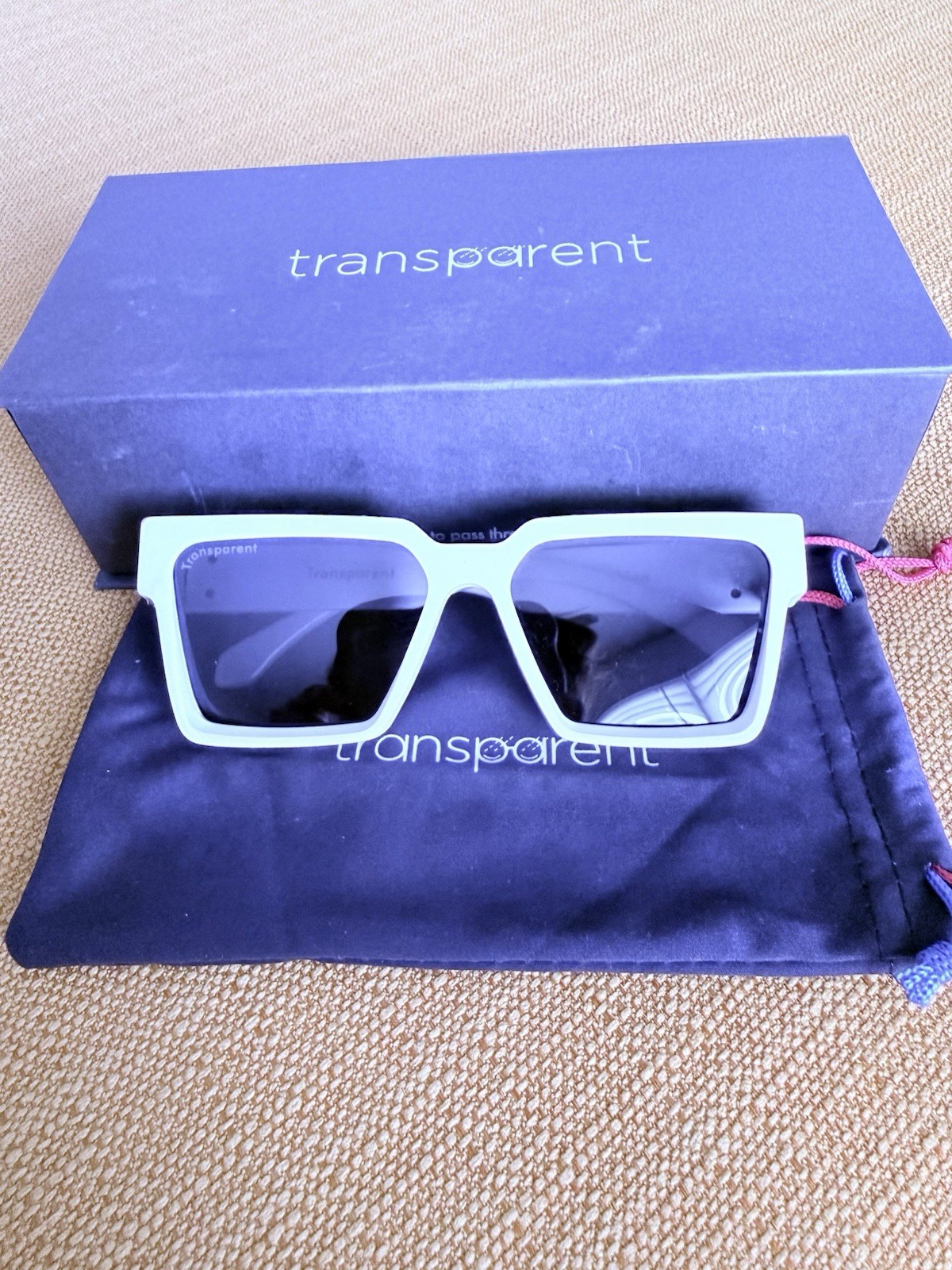 DESIGNER: Transparent Devon Sunglasses with gold detail. Box included.
